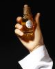 Holding a bottle of Brouq perfume